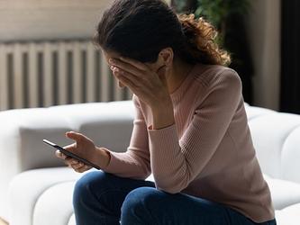 young woman stressed and upset by text message